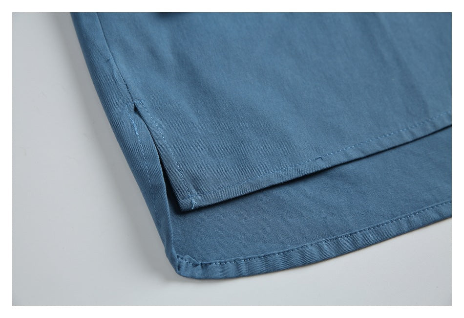 Close-up of the blue shirt hem, showing a side slit and stitched edges.