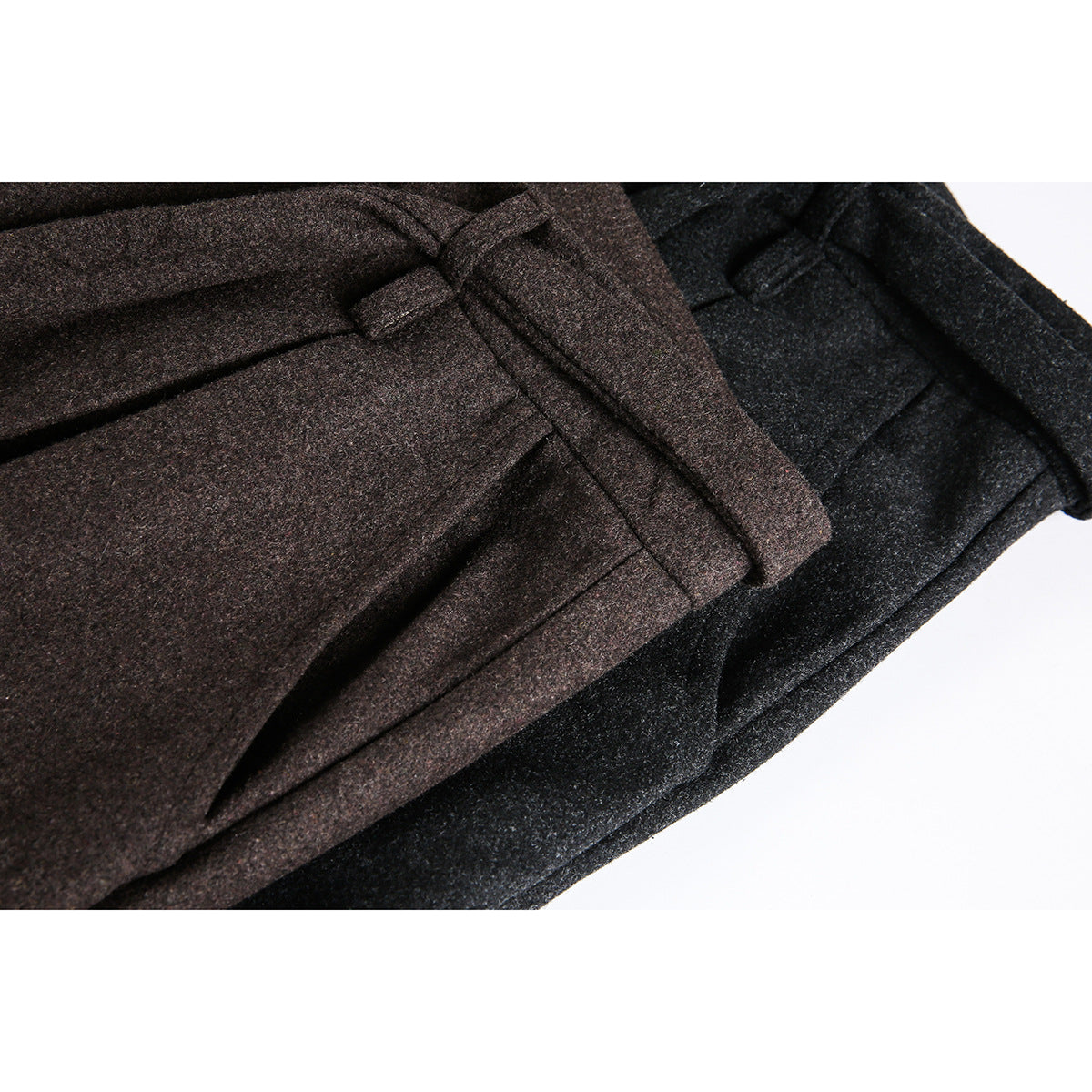 Close-up of brown and charcoal trousers showing the waistbands, belt loops, and front pleats.