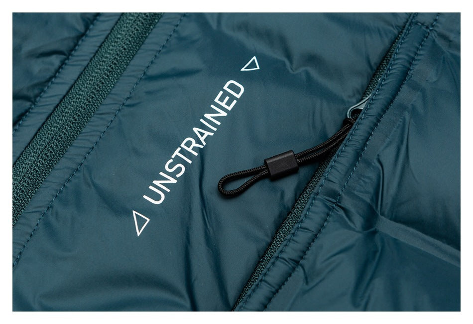 Teal jacket close-up showing a white UNSTRAINED print beside a black zipper pull.