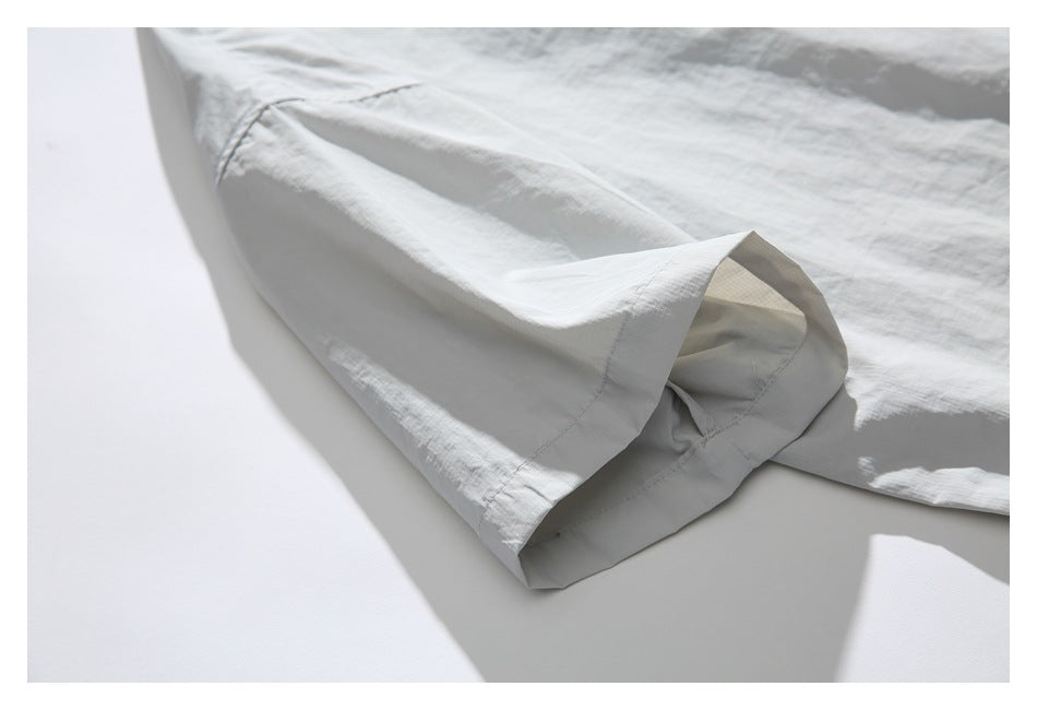 Close-up of the light gray pullover's short sleeve and wide hem.