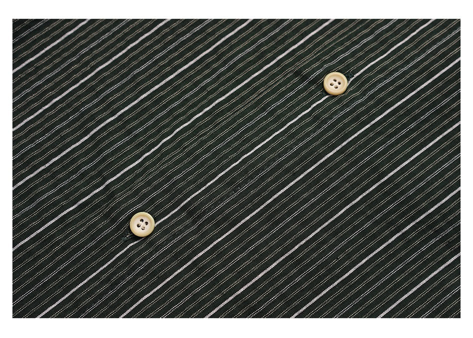 Close-up of fine light stripes on dark fabric with two cream-colored buttons.