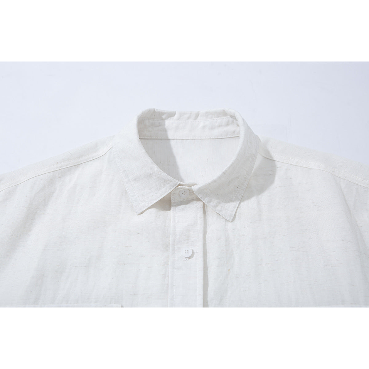 Close-up of a white short-sleeve button-up shirt’s pointed collar and front placket.