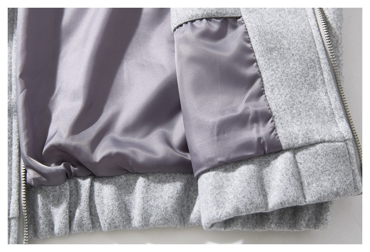 Close-up of the smooth gray lining and interior pocket inside a light gray coat.