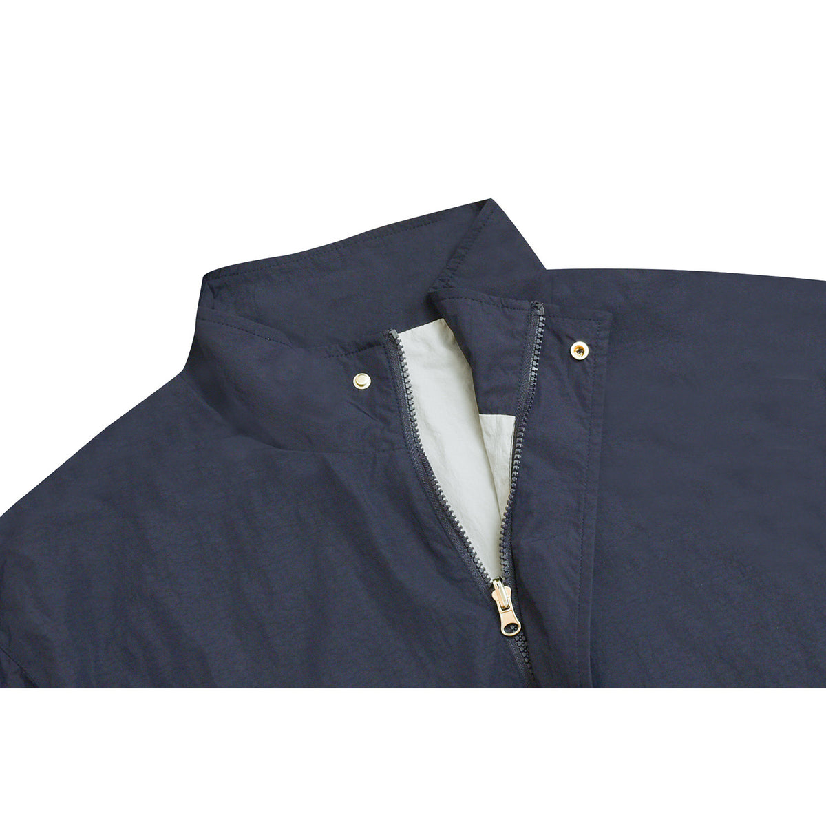 Close-up of a dark navy jacket collar with a partly open zipper, pale lining, and metal snaps.