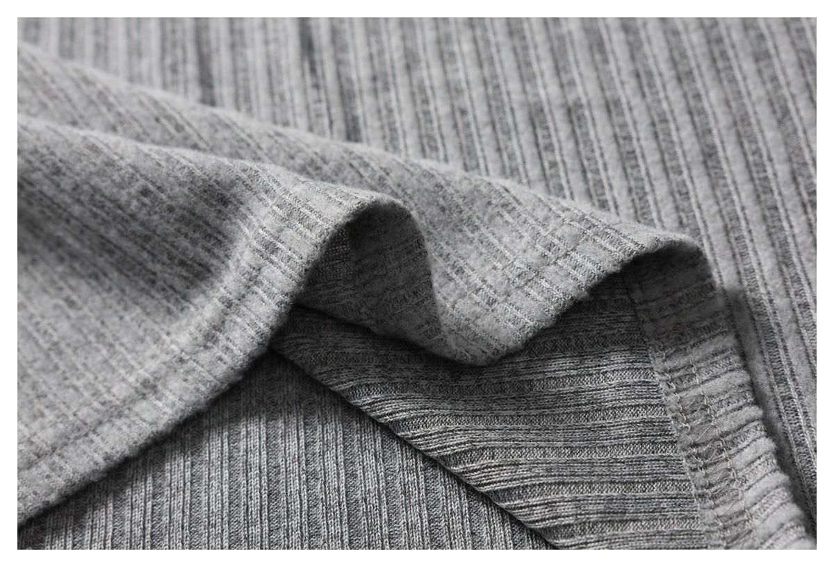 Close-up of folded gray ribbed fabric showing the underside and stitched seam.
