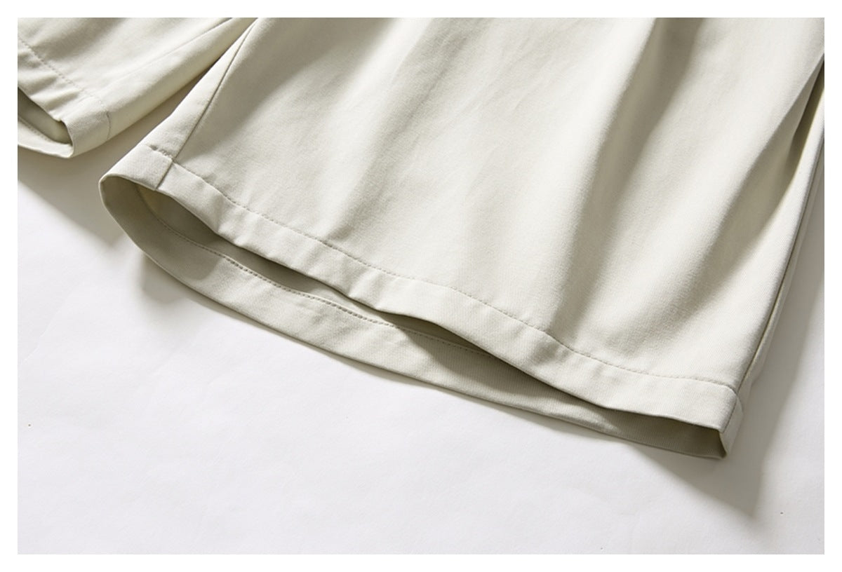 Close-up of the wide hem and side seam of a cream trouser leg.