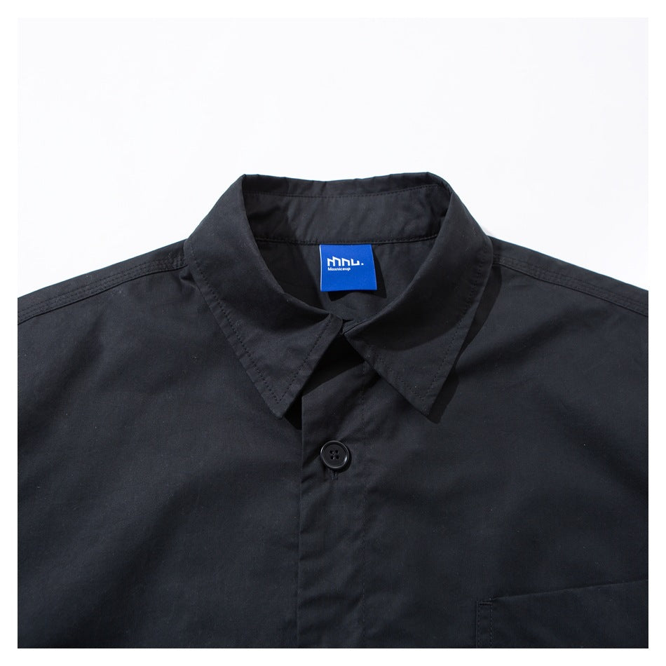Close-up of a black jacket's pointed collar, top button, and blue neck label.