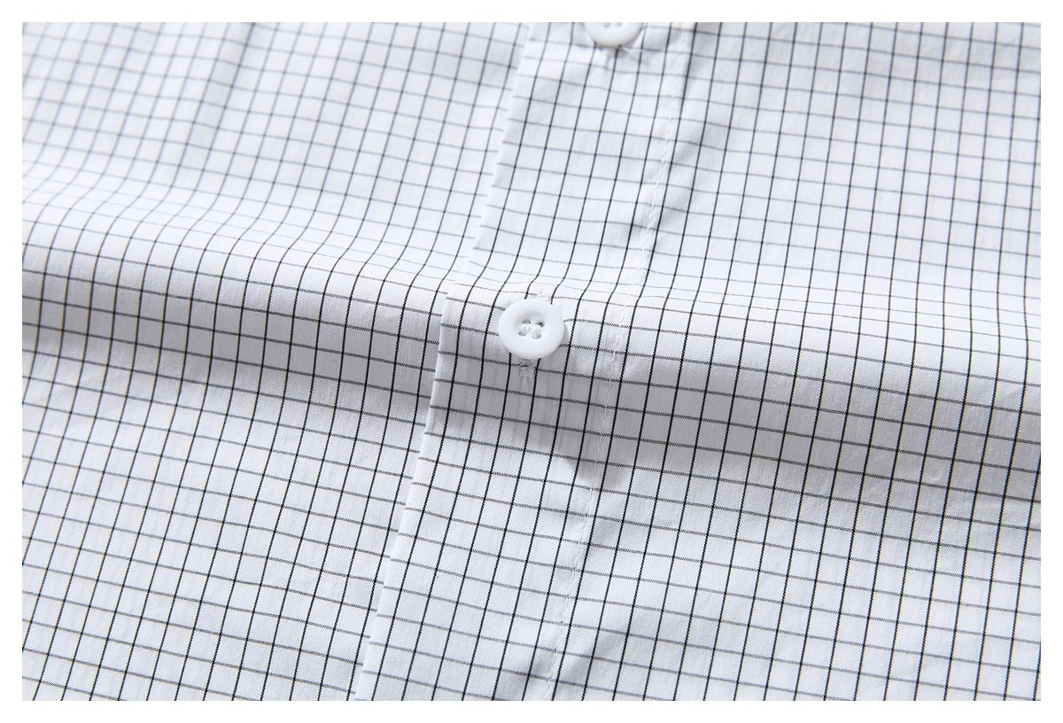 Close-up of the white shirt's black windowpane grid, front placket and white button.
