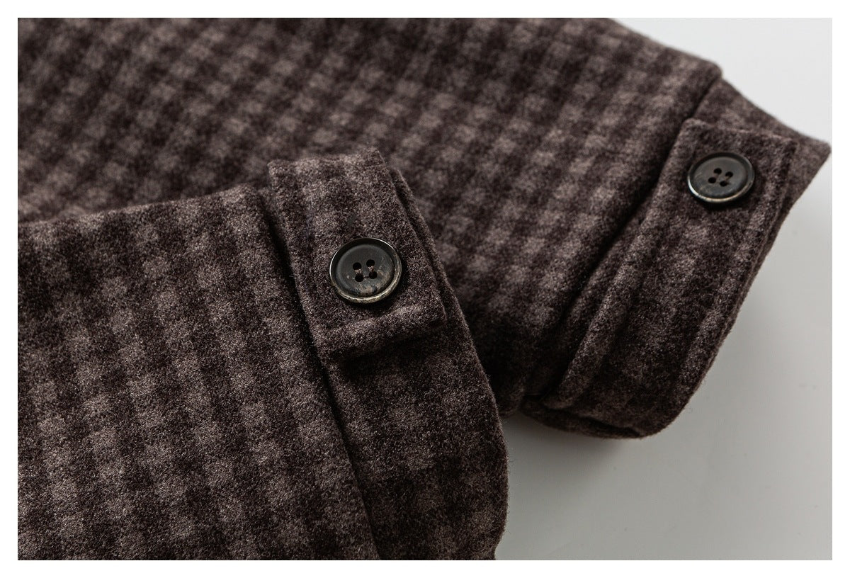Close-up of a dark buttoned cuff tab on a dark brown mottled coat sleeve.