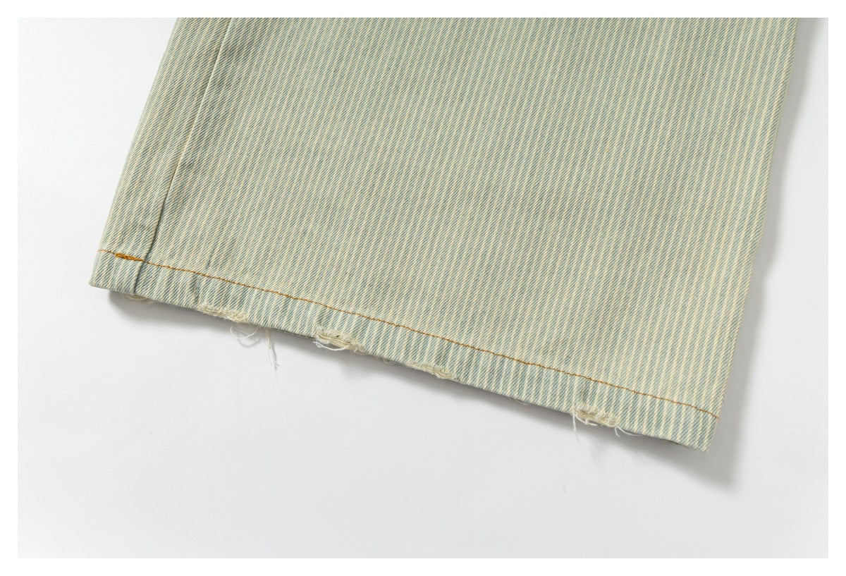 Close-up of the stitched hem with slight fraying on pale blue and cream striped denim.