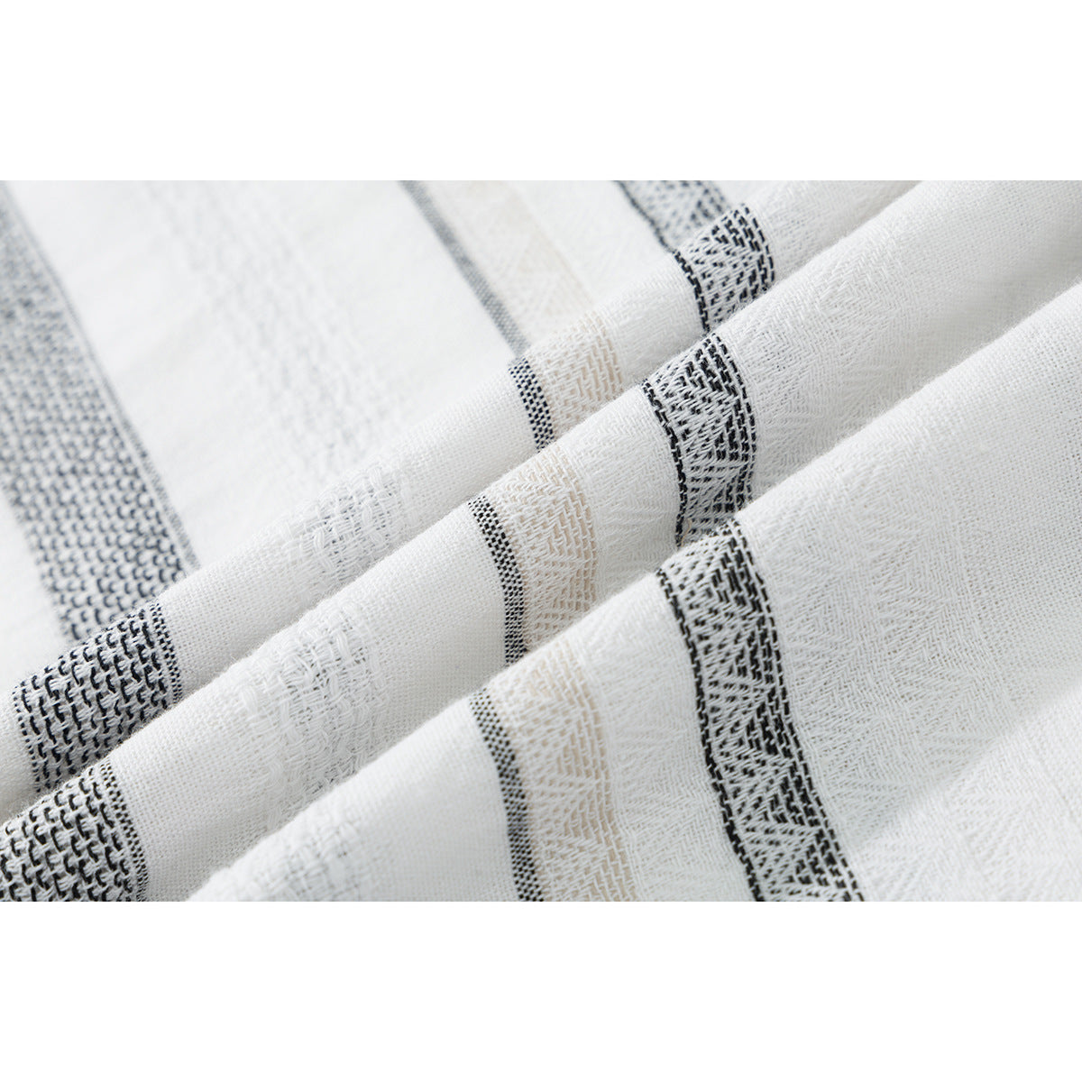 Macro view of the white shirt fabric with textured black and beige stripes.