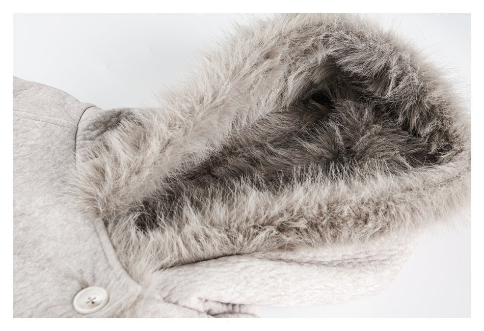 Close-up inside the light gray jacket's hood, showing dense fur lining and a button near the neckline.