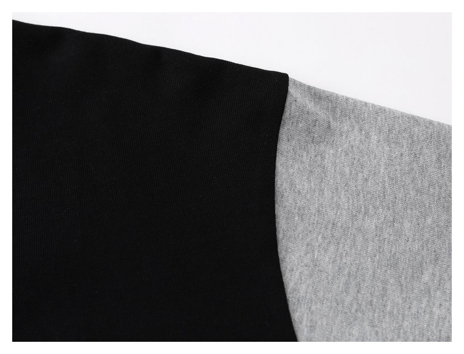 Close-up of black and heather-gray fabric meeting at a curved seam.