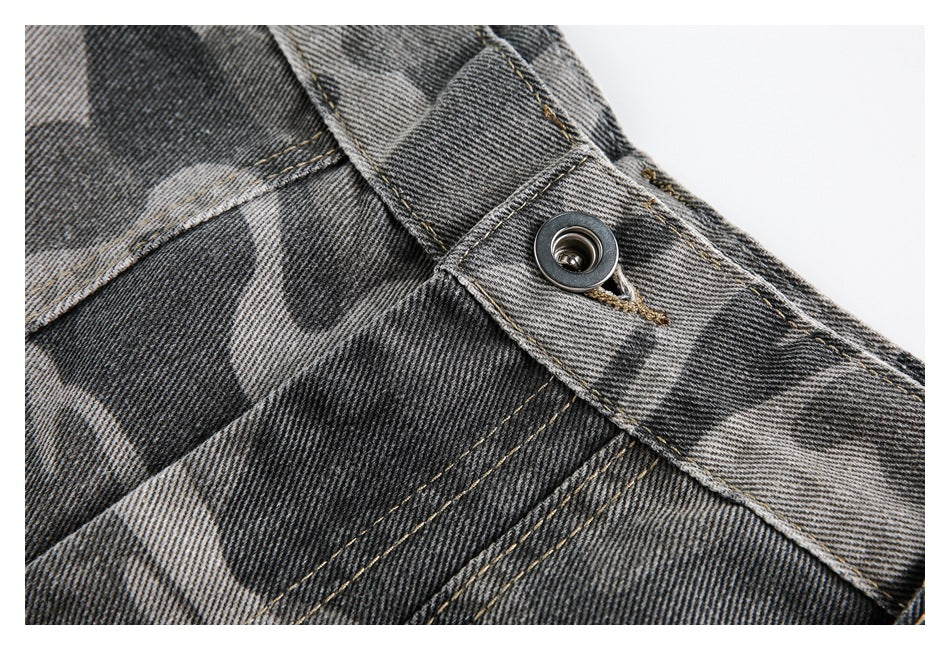 Close-up of the metal waistband button and stitched fly on gray camouflage shorts.