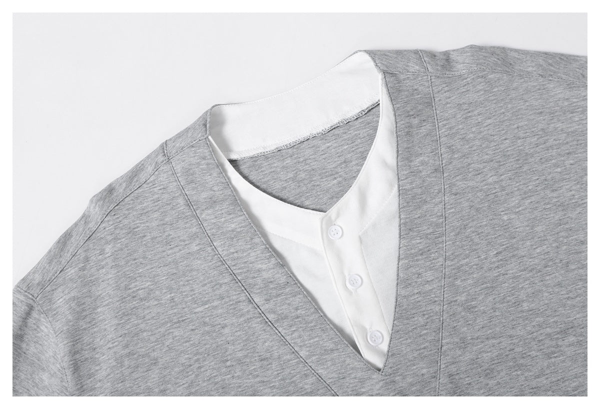 Close-up of a heather gray V-neck top with a white three-button inner placket and neckline.