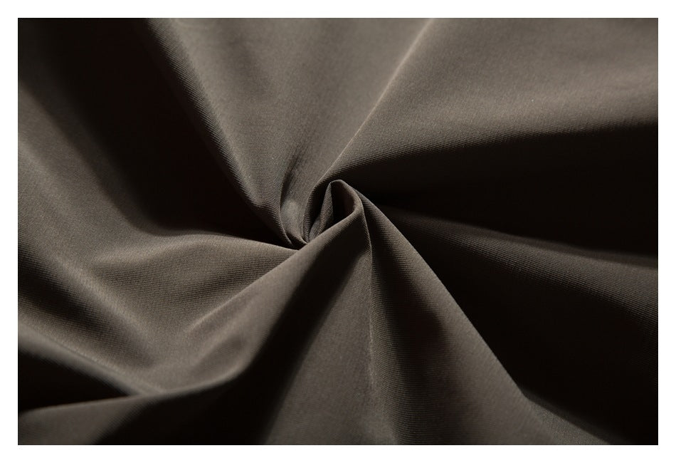 Close-up of dark brown fabric gathered into a twist, showing its smooth surface and drape.