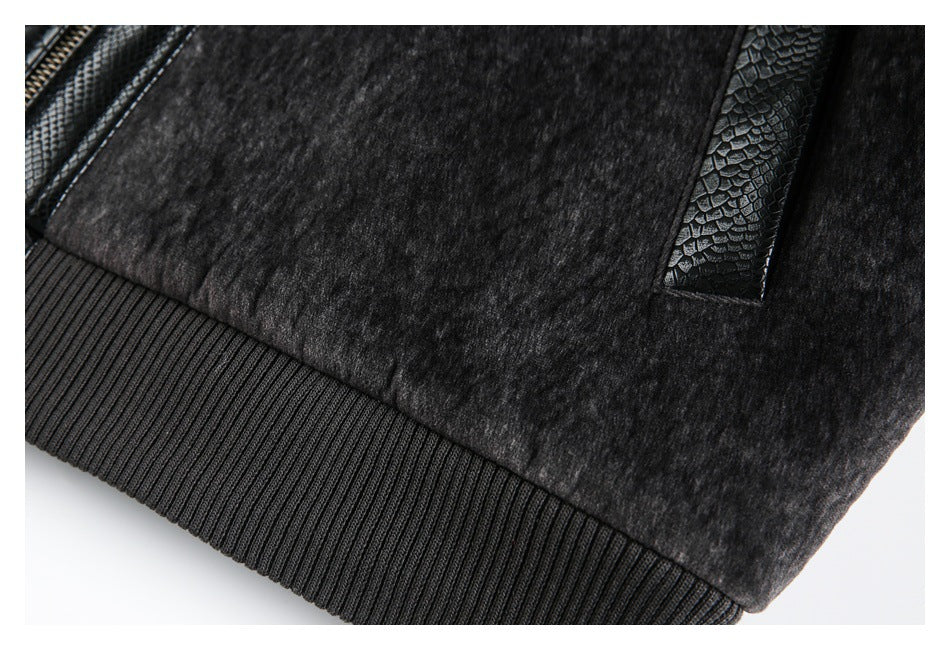 Close-up of the jacket's ribbed charcoal hem and black textured trim beside a pocket opening.