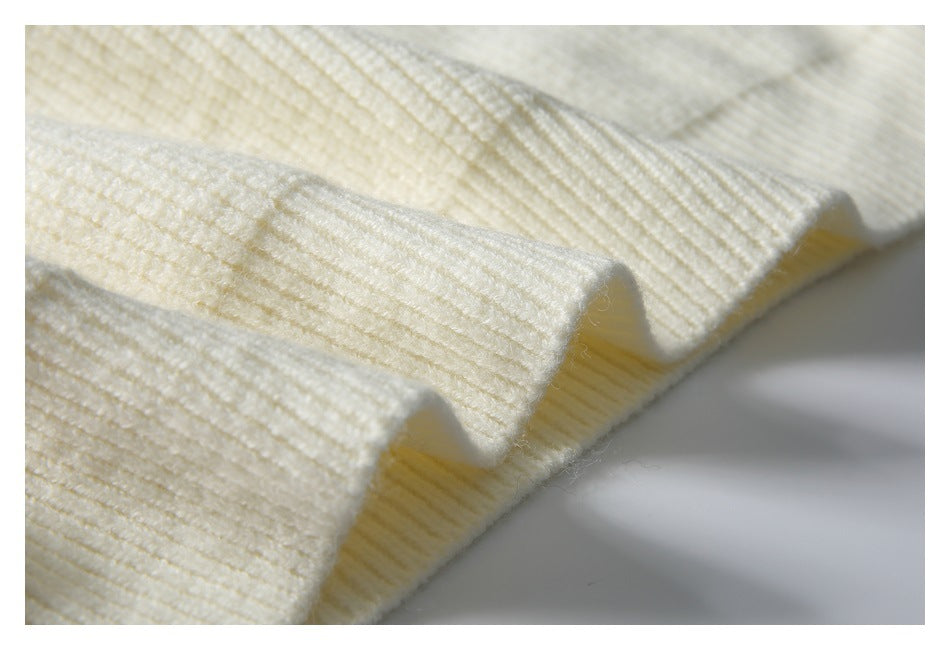 Close-up of the ivory sweater's ribbed knit and folded ribbed edge.