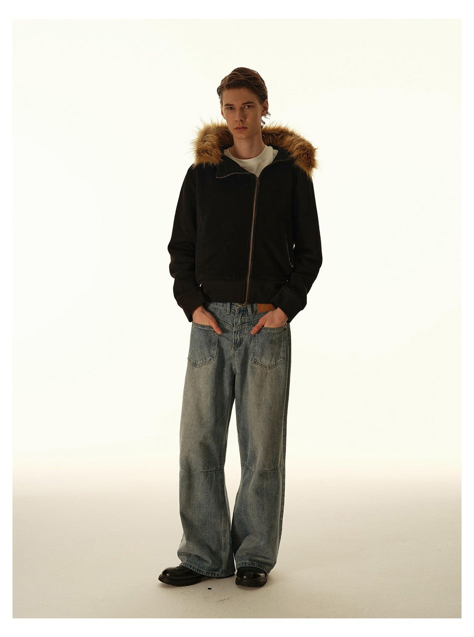 Full-length model wearing a black zip-front jacket with a brown fur-trimmed hood and loose blue jeans.
