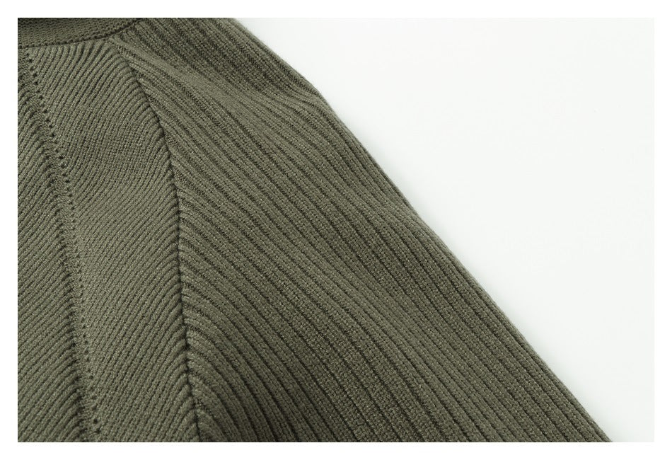 Close-up of the ribbed knit sleeve and seam on an olive-gray garment.