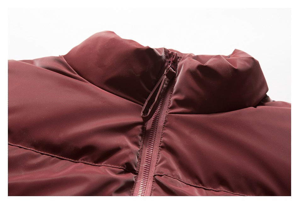 Close-up of a burgundy puffer jacket's high collar and front zipper.