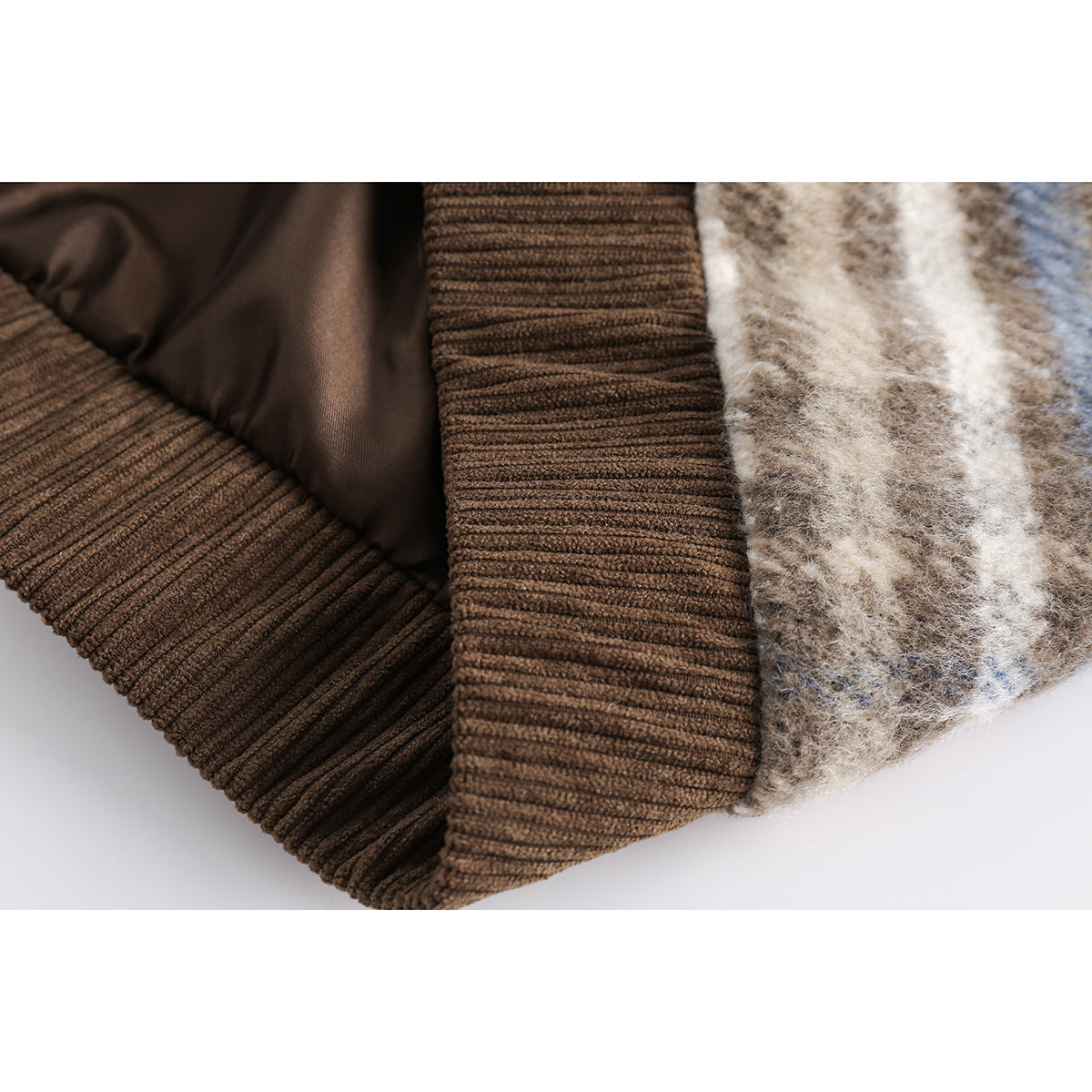 Close-up of the brown ribbed knit hem and cuff beside the plaid shell and dark lining.