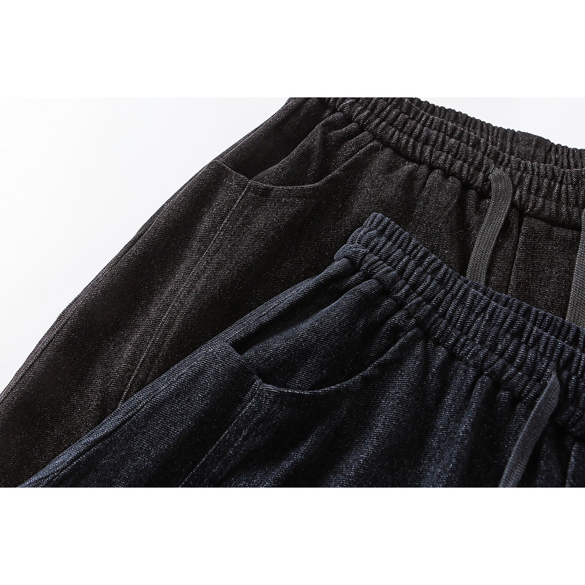 Close-up of dark wide-leg pants showing an elastic drawstring waist and curved front pockets in two shades.