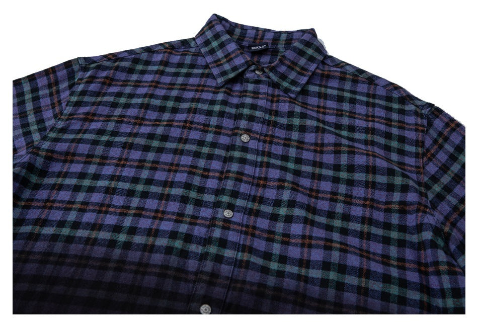 Cropped front view of a purple, teal, and black plaid button-up shirt with a pointed collar.