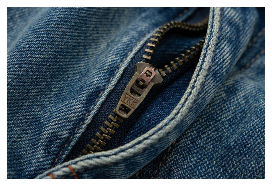 Close-up of the metal zipper and fly seam on blue denim jeans.