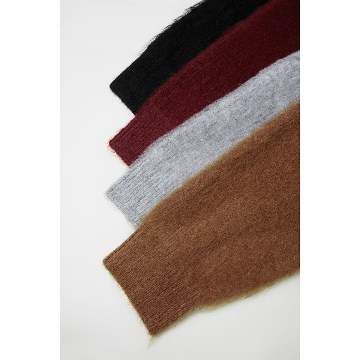 Four overlapping knit sweater sections in black, burgundy, gray, and brown, showing ribbed cuffs.