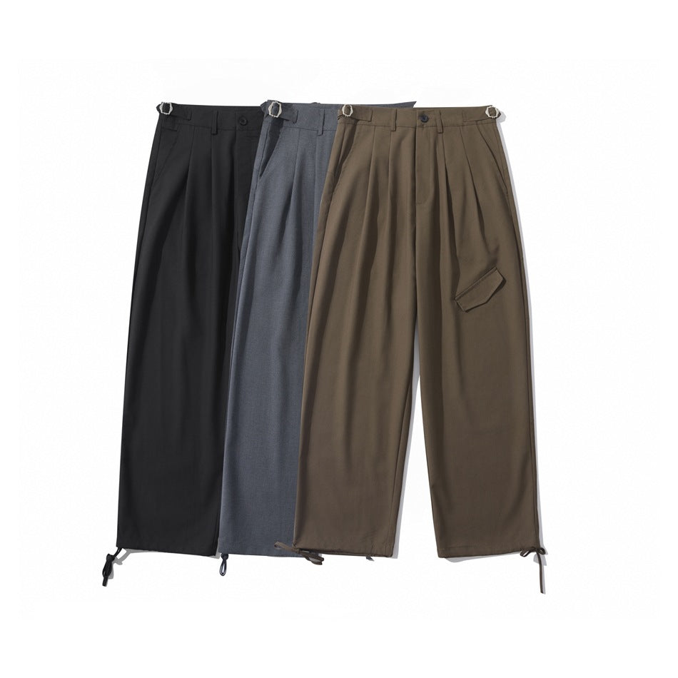 Three pairs of wide-leg pleated trousers in black, charcoal gray, and brown, shown from the front.