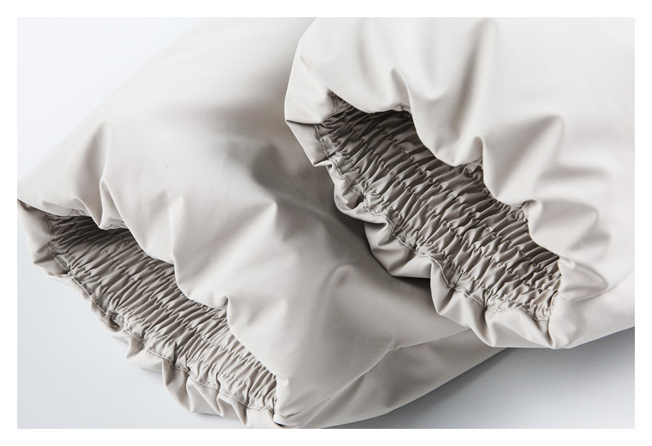 Close-up of pale gray fabric with two gathered elastic sections.