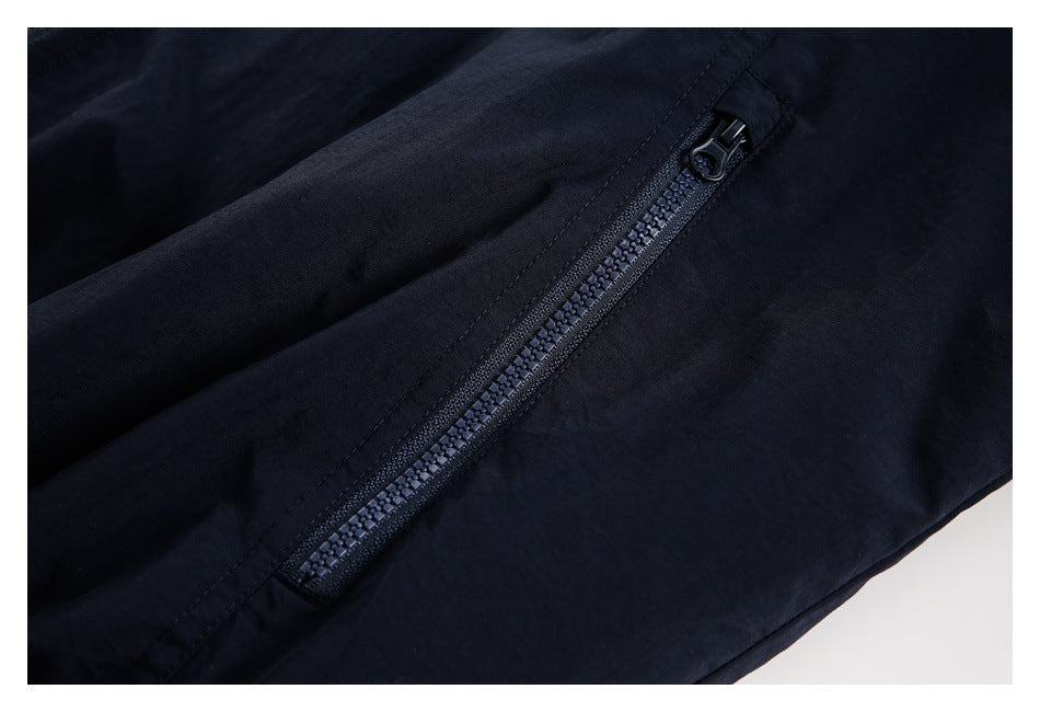 Close-up of a black jacket's diagonal zippered pocket.