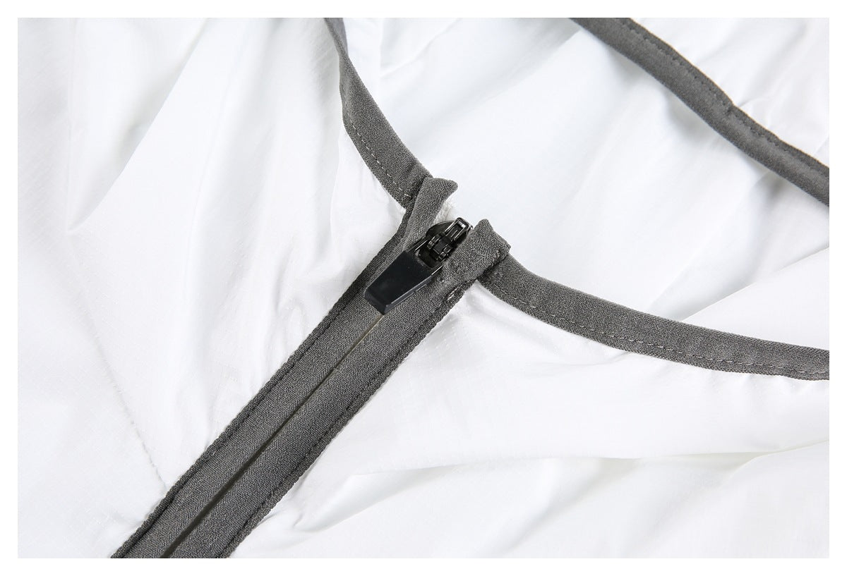 Close-up of a black zipper set into dark gray binding on white fabric.