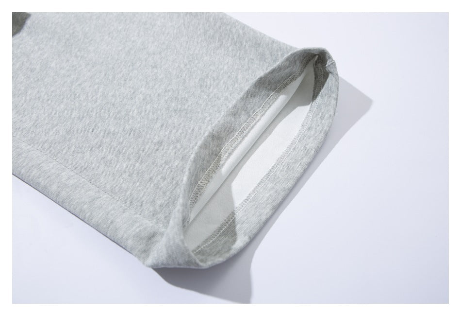 Close-up of the open hem of a light gray sweatpant leg, showing the stitched edge and inside seam.