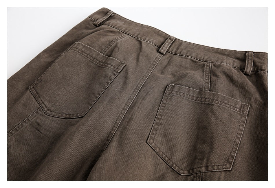 Rear view of brown trousers, cropped to show the waistband, belt loops, and two back pockets.