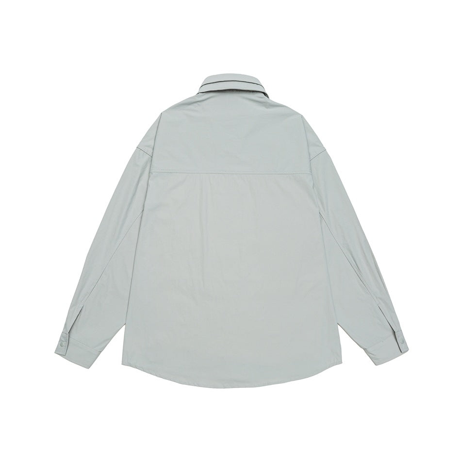 Back view of a pale gray-green long-sleeve collared shirt laid flat, with a yoke seam and buttoned cuffs.
