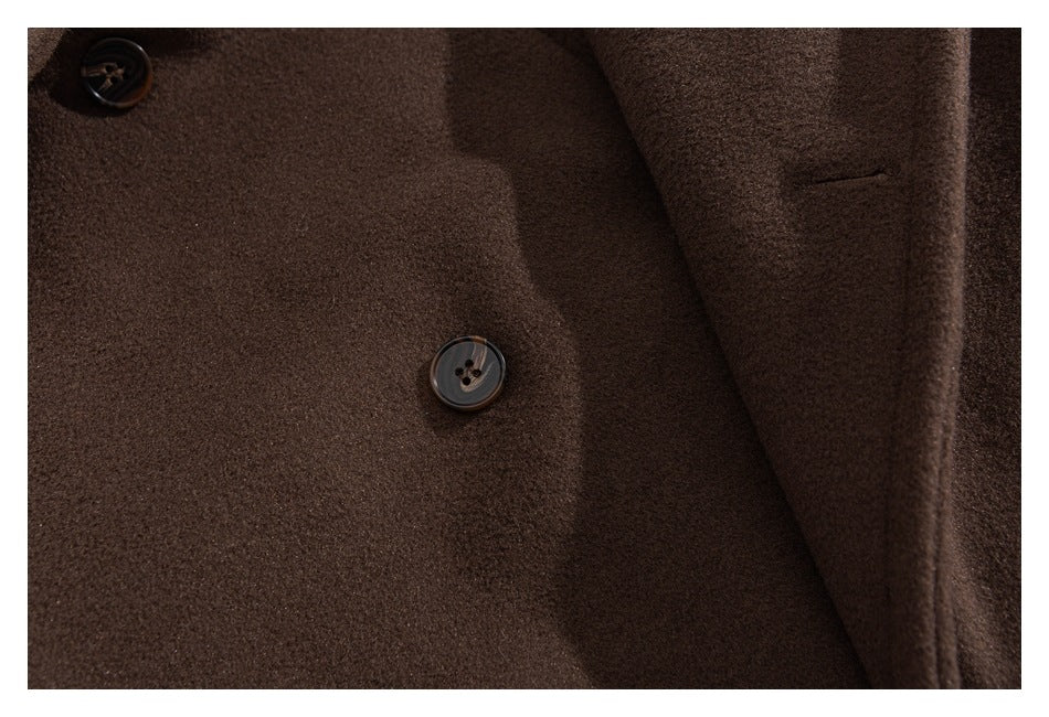 Close-up of the brown coat front, showing dark buttons and a narrow pocket opening.