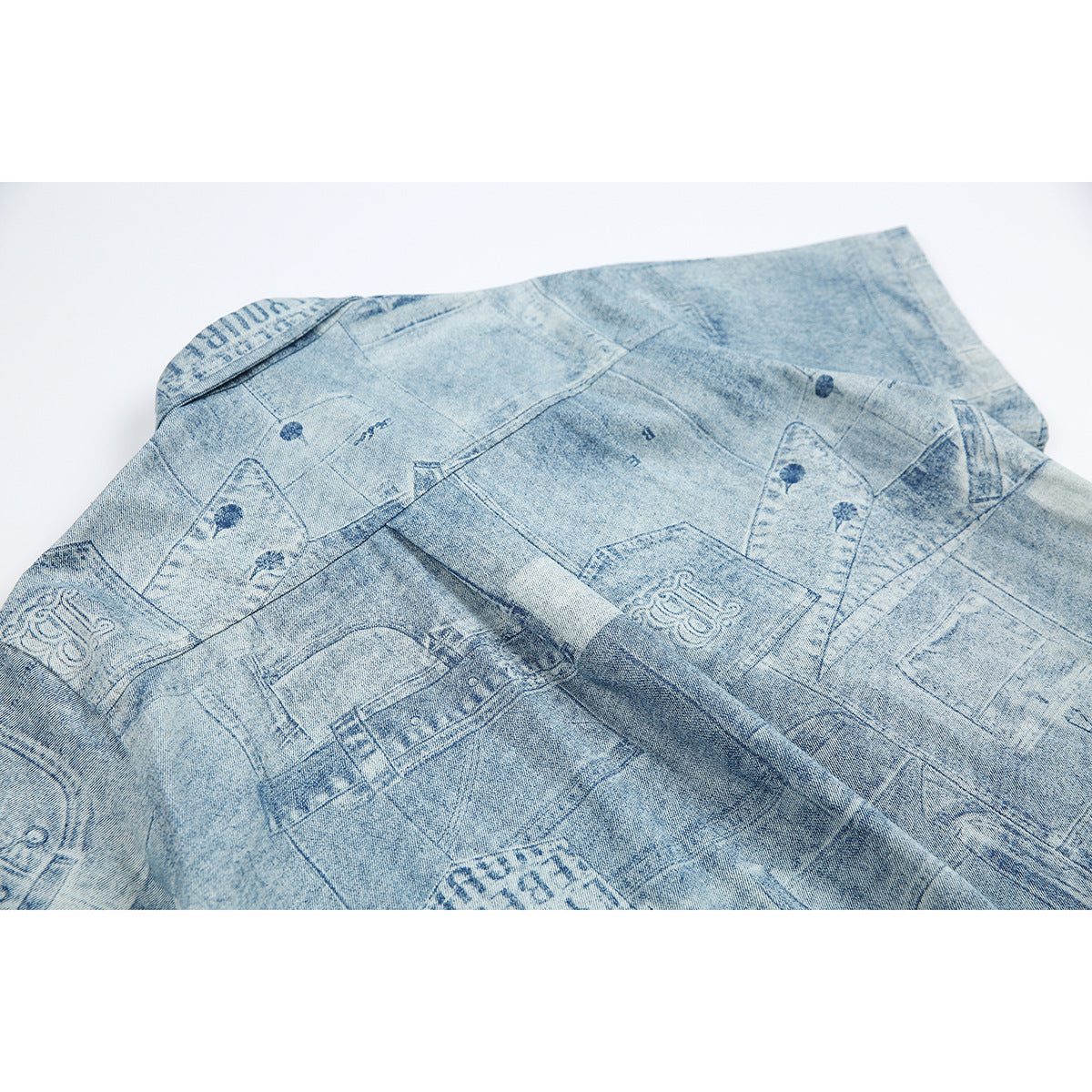 Close-up of the shirt's back, with pale blue denim-style patchwork print and stitched panel seams.
