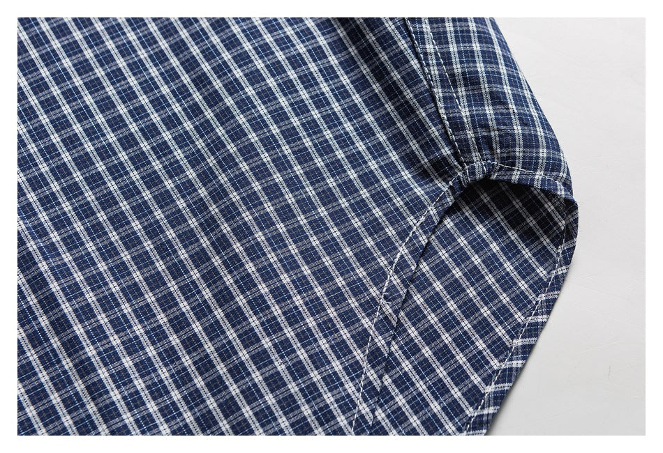 Close-up of the blue plaid shirt's underarm seam and sleeve opening.