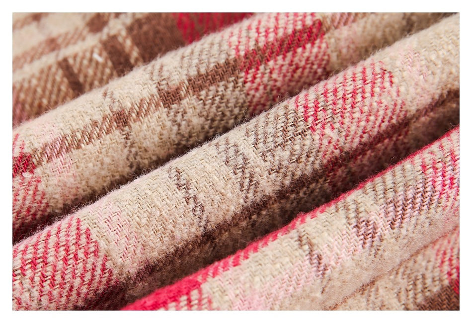 Macro view of the red, cream, and brown plaid fabric's woven texture.