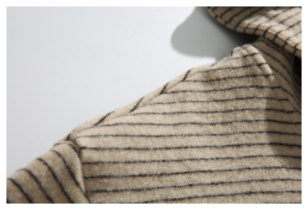 Close view of a beige sleeve and shoulder area with thin dark stripes.