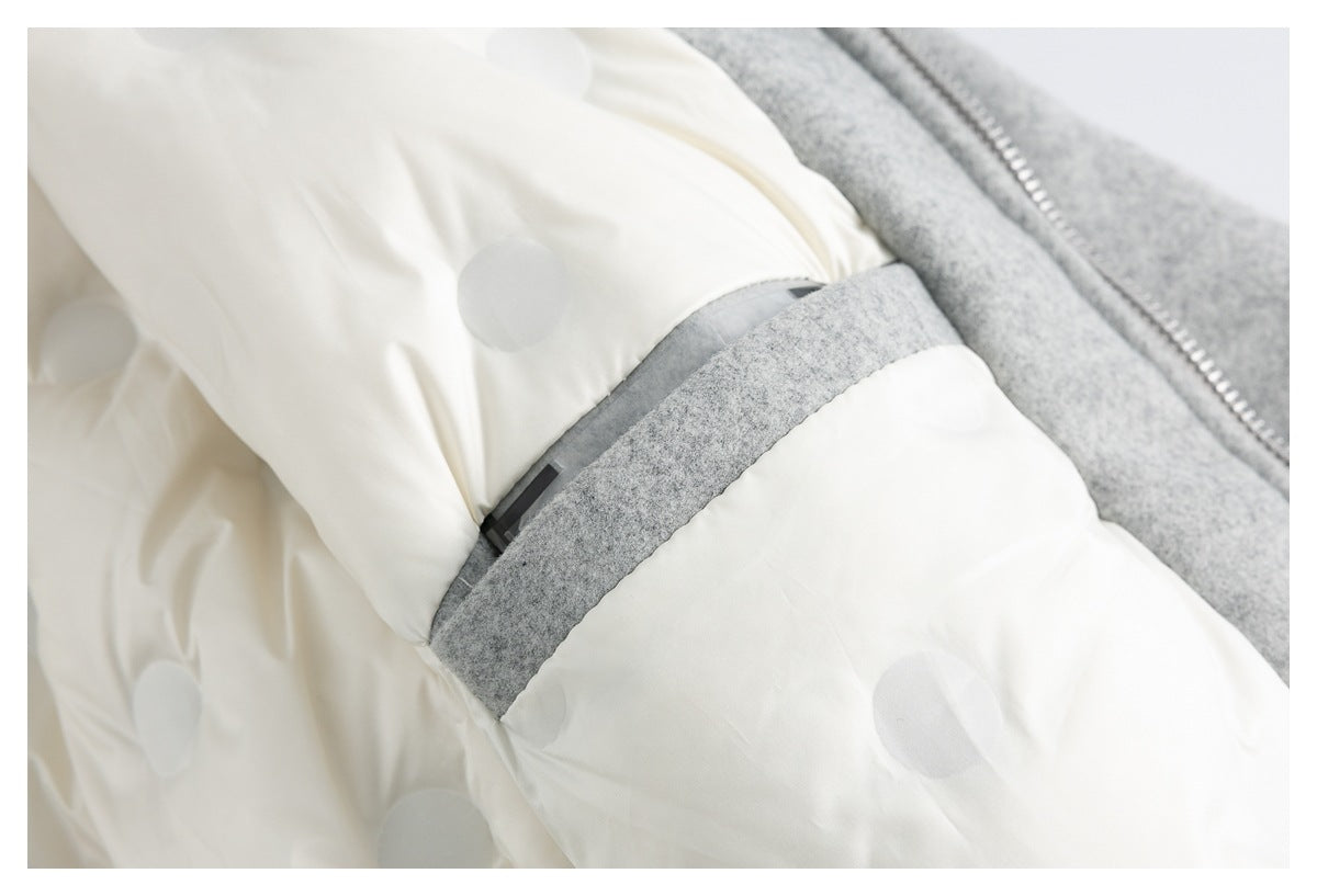 Close-up of the jacket's off-white dotted lining, gray trim, and a small dark tab.