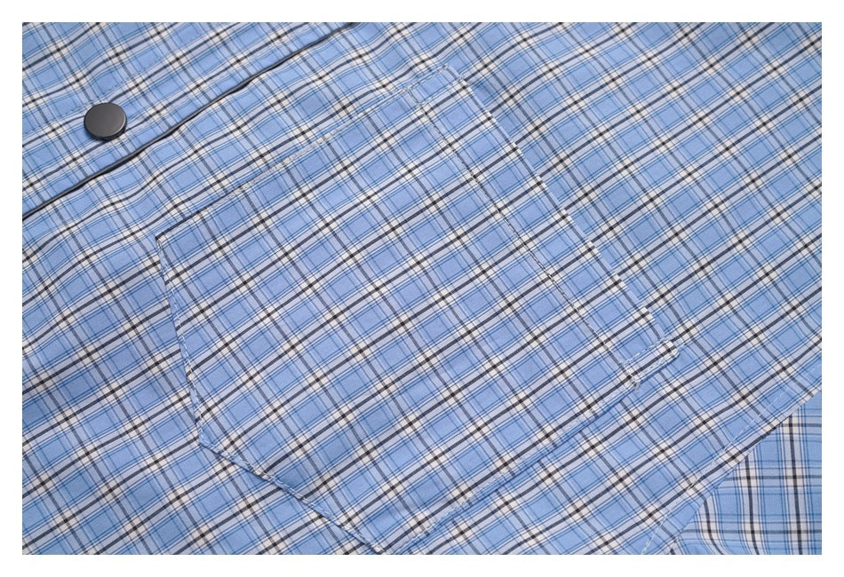 Close-up of a blue plaid garment showing a large matching chest pocket and dark button.
