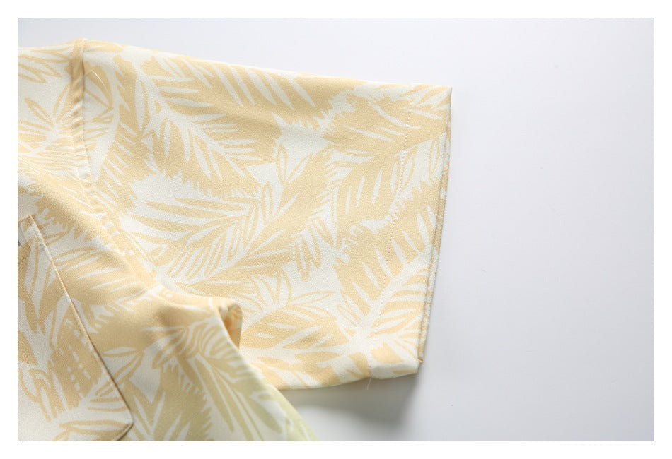 Close-up of the short sleeve and cuff of a cream shirt with a pale yellow leaf print.