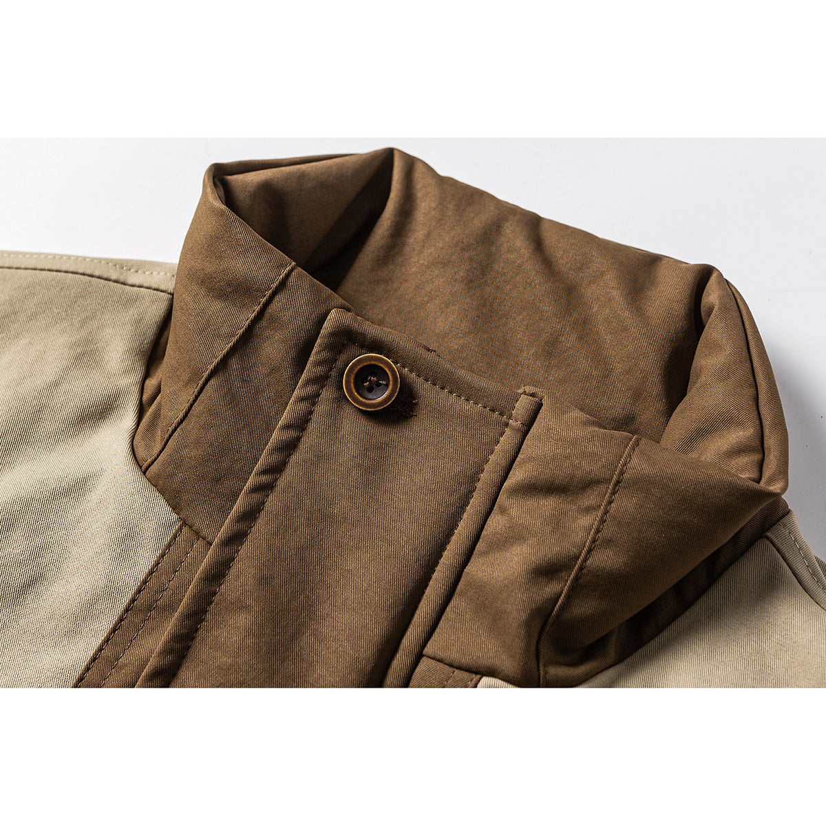 Close-up of the jacket's brown collar, buttoned front tab and contrasting beige shoulder panel.