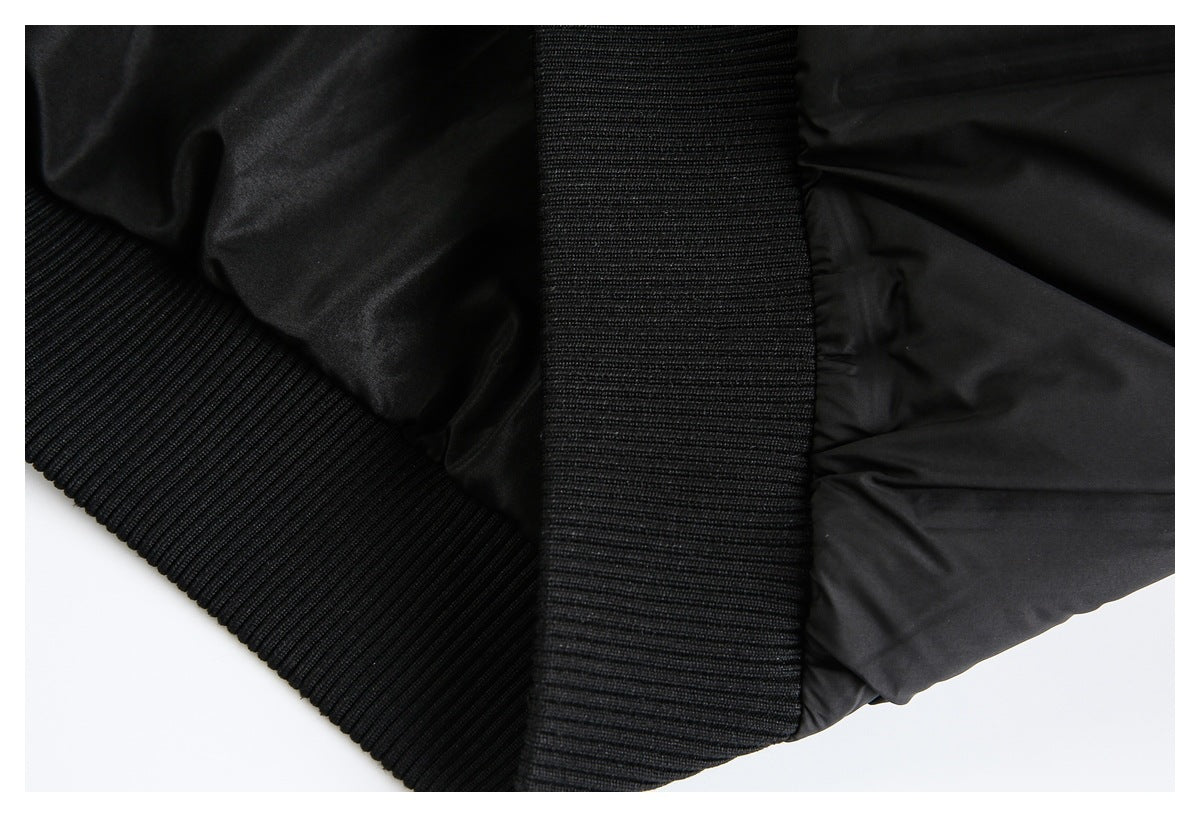 Close-up of a black jacket's ribbed knit trim beside its padded shell.