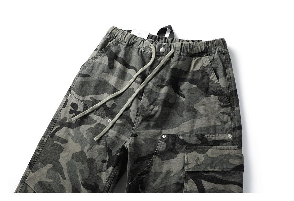 Front view of gray and black camouflage cargo pants with an elastic waist, drawcord, and flap thigh pocket.
