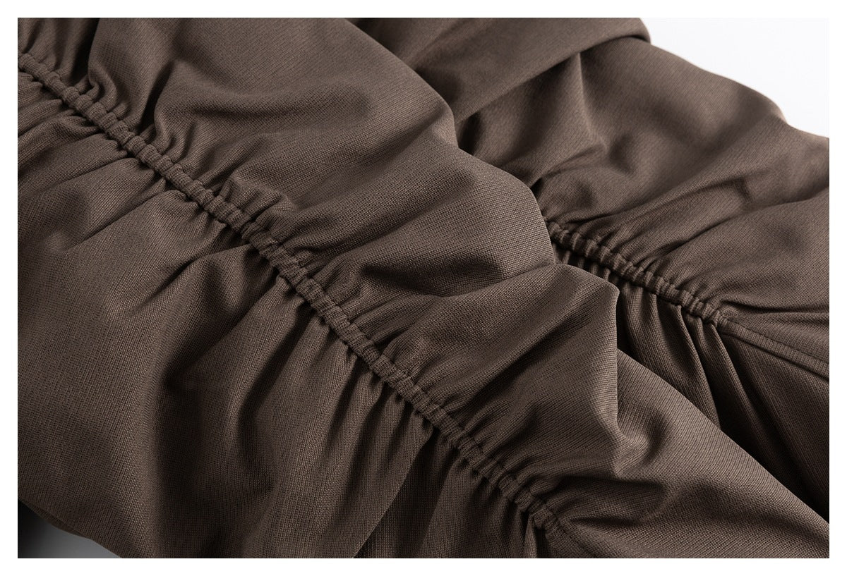 Close-up of brown fabric with gathered seam construction.