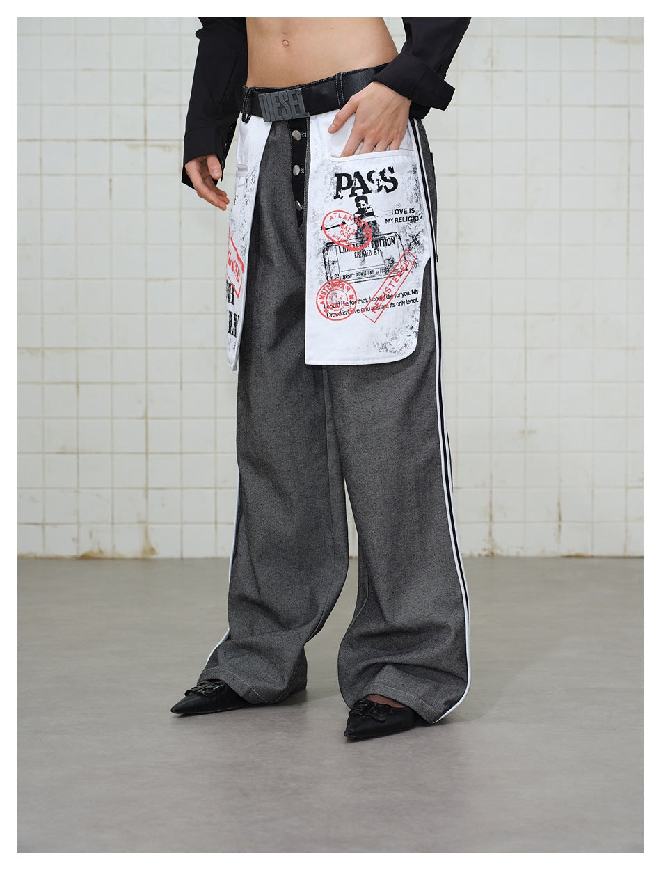 Model wearing wide-leg gray jeans with white printed pocket panels and side stripes, hand resting in pocket